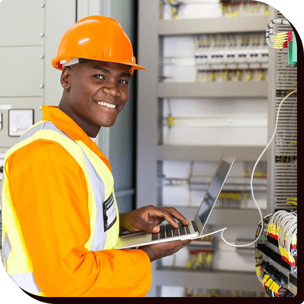 A man in an orange vest and hard hat holding a laptop.